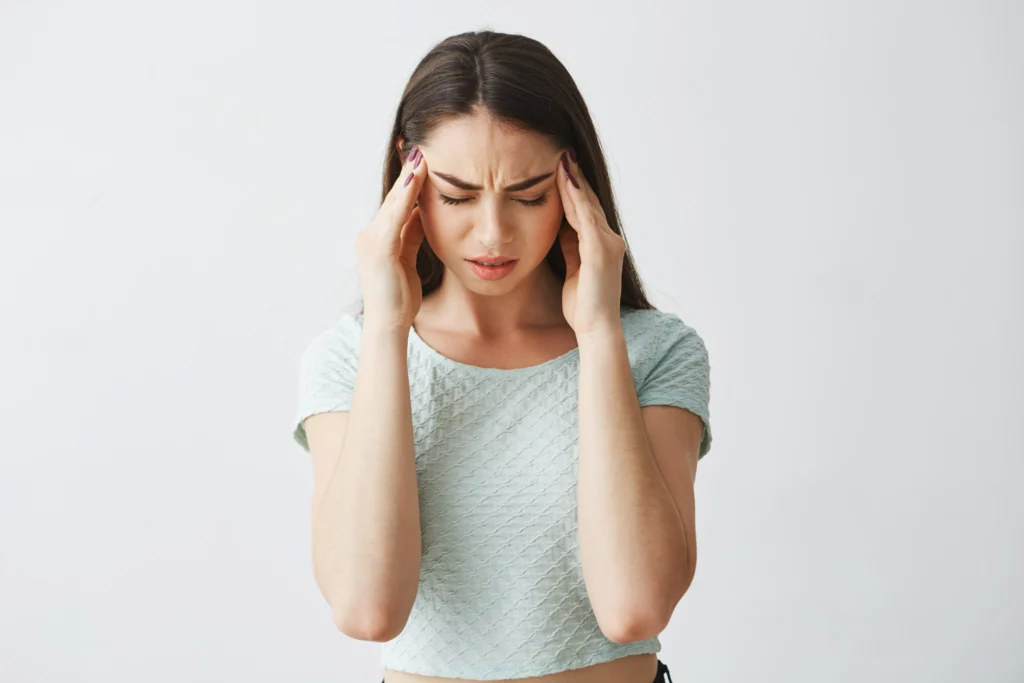 young beautiful brunette girl frowning touching temples headache isolated white background scaled
